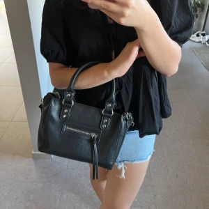 Väska - Super snygg väska. Endast använd fåtal gånger. Ett ”band” har där emot åkt av på ena sidan. 