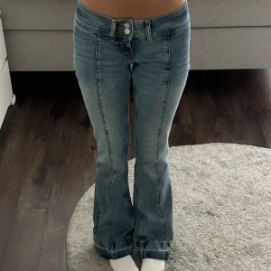 Lågmidjade utsvänga jeans - Jättefina jeans från Monki! Använda väldigt sparsamt och har inga defekter. Har sprätt upp jeansen längst ner så de ska passa mig som 170cm bättre! 💗☺️Tror inte de säljs längre så passa på!!🥰