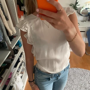 Blus med volanger  - Supersöt blus i glansigt material med volanger på axlarna. Passar xs/s 