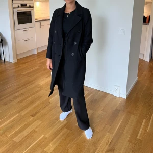 Svart kappa - Riktigt snygg svart kappa. Använts höst/vinter/vår, så den är varm.  Köptes i höstas för 2000kr på MQ  Storlek XS men passar också S 