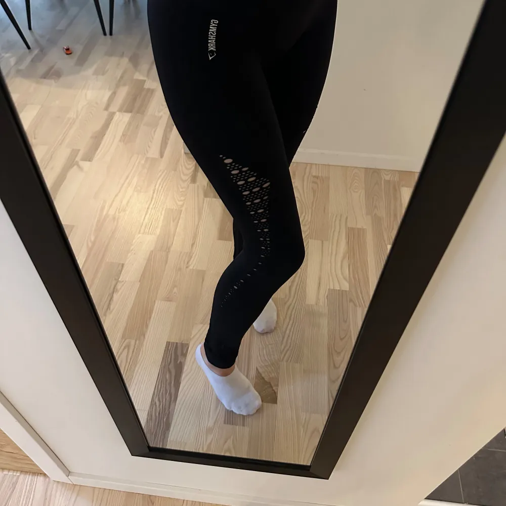 Ett svart träningsset från Gymshark bestående av en sport-bh och leggings. Setet är tillverkat i ett stretchigt och bekvämt material med andningsfunktion. Leggingsen har ett hålmönster längs benen och sport-bh:n har breda axelband för extra stöd. Nypris 920:- för setet, mitt pris 450:-. I nyskick! . Sportswear.