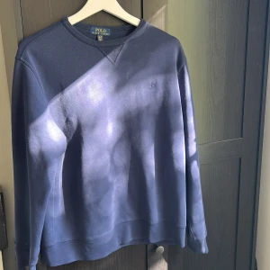 Blå sweatshirt från Polo Ralph Lauren - Säljer en klassisk blå sweatshirt från Polo Ralph Lauren i storlek cirka 174. Tröjan har rund halsringning, långa ärmar och diskret broderad logga på bröstet. Perfekt för en avslappnad och stilren look.