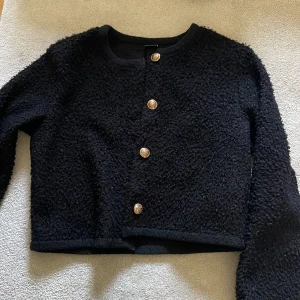 Svart kofta med guldknappar från Gina Tricot - Säljer en svart, croppad kofta från Gina Tricot med dekorativa guldknappar framtill. Funkar även som jacka🤍säljer då jag har 2