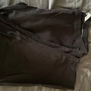 Svarta leggings - Svarta korta leggings med elastisk midja, perfekta för en enkel och bekväm stil. Tunt och stretchigt material som sitter tight längs benen. Passar till många olika outfits och är lätta att matcha.