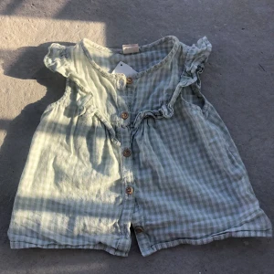 En grön liten söt klänning - En grön liten söt klänning med knappar i väldigt bra skick i storlek 80