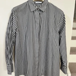 Skjorta jeannie striped black från style in.  - Skjorta Jeannie striped black från Styelin. Strl S. Nyskick. Knappt använd. 97% bomull. 3 % spandex. Svart och vit randig. Köpt för 2400kr. 