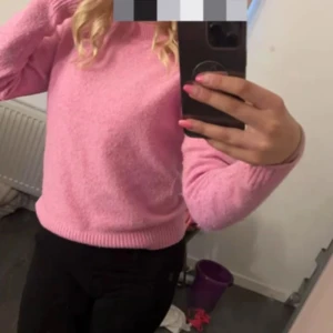 Rosa stickad tröja - Mysig rosa stickad tröja med rund halsringning och långa ärmar. Perfekt för att hålla sig varm under kyligare dagar. Enkel och stilren design som passar till mycket.