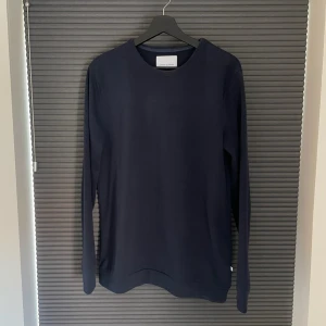 Mörkblå crewneck från Samsøe Samsøe - Säljer en stilren mörkblå långärmad tröja från Samsøe Samsøe. Tröjan är tillverkad i ett mjukt material och är relativt tunn. Enkel och klassisk design utan mönster eller detaljer. Storlek L men passar även för M. Tillsynes inga defekter.