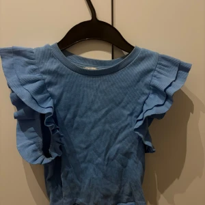 Blå ribbad topp med volangärmar - Supersöt blå ribbad topp från Zara med korta volangärmar. Storlek S men skulle säga att den sitter mer som XS💕