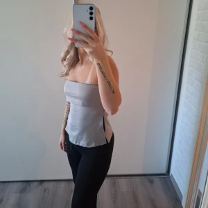  tubtopp - Säljer en tubtopp med slits i sidorna. Helt ny