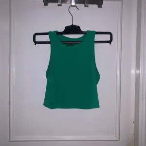 Grön croppad linnetopp från SHEIN - Snygg grön croppad linnetopp från SHEIN. Modellen är ärmlös med rund halsringning och enkel, stilren design. Perfekt att matcha med jeans eller kjol för en trendig look.