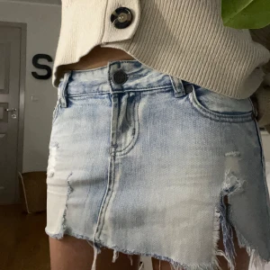 Lågmidjad jeans kjol  - Snygg Lågmidjade jeans kjol, har två  tydliga defekter där en är igensydd men inget som påverkar användningen. 