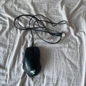 Svart gamingmus Roccat Kone Pure - Säljer en svart gamingmus från Roccat, modell Kone Pure. Musen har USB-anslutning och flera programmerbara knappar på sidan. Perfekt för gaming och har en ergonomisk form med Roccat-loggan på ovansidan.