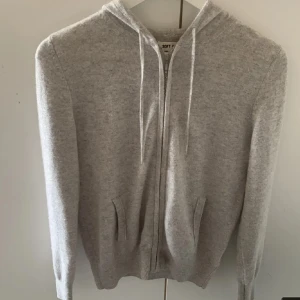 Greige hoodie från soft goat  - Säljer en stilren beige/grå hoodie med dragkedja och huva. Tröjan har långa ärmar och ribbade muddar vid ärmslut och nederkant. Perfekt för en avslappnad look. Skick 9/10, nypris ligger på 2995kr men jag säljer den enbart för 1500kr, priset går att diskuteras!