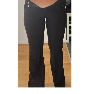 Svarta bootcut byxor med knappar - Snygga kostym byxor. Säljer pågrund av att dom är för små. Jag är 160cm och dom är lite för långa för mig.