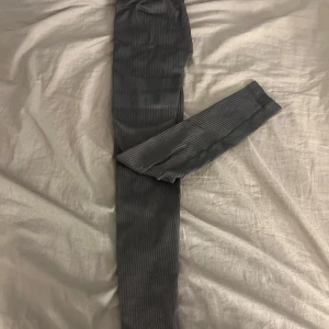 Grå ribbade tights från Stronger - Säljer ett par grå ribbade tights från Stronger i storlek XS. De har hög midja och är stretchiga. Finns inte kvar på hemsidan men köptes nya för ca 499kr om jag inte minns fel. Säljer då dom blivit för små