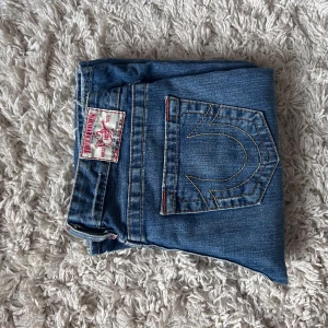 Blåa True Religion  - Säljer ett par lågmidjade bootcut true religon jeans. Dem är st 28 men passar hela vägen ner till 26.                                   Mer bilder skickas på begäran. 