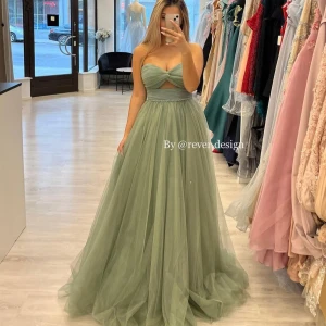 Ljusgrön balklänning med tyll och cut-out - Säljer en ljusgrön långklänning från Revendesign med tyllkjol och axelbandslös överdel. Klänningen har en snygg cut-out detalj under bysten och markerad midja. Perfekt för bal eller festliga tillfällen. Aldrig använd ny med prislapp mer bilder finns