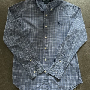 Rutig Ralph Lauren Skjorta - Blå (Stl S) - Säljer denna snygga rutiga skjorta från Ralph Lauren. Skjortan är i gott skick och har ett nypris på ca 1500kr