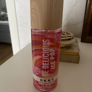 DKNY Be Delicious Ice Pop Very Cherry - Fräsch och fruktig body mist från DKNY i doften Very Cherry. Flaskan är rosa med färgglada mönster och har ett snyggt lock i träimitation. Perfekt för dig som gillar söta och bäriga dofter med en lekfull twist.