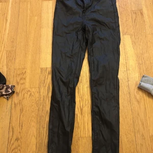 Svarta skinny byxor i bomull - Svarta byxor med skinny passform och klassisk midja. Tillverkade i bomullsmaterial med lätt glansig finish. Perfekta för dig som gillar en tight och stilren look.