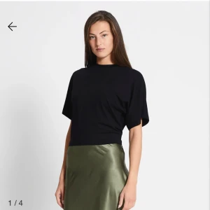 Svart utsvängd ärm T-shirt med loose fit - En svart t-shirt med rund hals och längre utsvängda armar. Modellen är loose fit och har en enkel, stilren design utan tryck eller mönster. Perfekt att matcha med kjol eller jeans för en clean look.💕