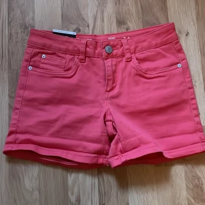 Snygga lågmidjade rosa shorts - Jättesnygga lågmidjade rosa shorts som är perfekta till sommaren, och skulle vara så fina när man är brun.💞 Köpta på secondhand med märket C Denim.💕Midjemåttet är ca 35cm och längden är ca 29cm. Materialet är stretchigt vilket gör de väldigt bekväma!🙌🏻 De är i ny skick och man ser inget tecken på användning, samt lappen på shortsen är kvar!💗