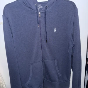 Ralph Lauren Hoodie - Ralph Lauren Hoodie storlek M. Använd men i bra skick. Enda felet på den är två väldigt små hål i högerfilen och en precis under som man kan se på sista bilden.