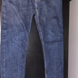 Levi's 512 blå jeans W32 L32 - Säljer ett par klassiska Levi's 512 jeans i blå denim. Modellen har en slim passform med raka ben och snygga kontrastsömmar. Perfekta för dig som gillar en tidlös look och vill ha jeans som sitter snyggt hela dagen.