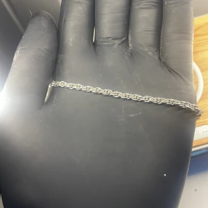 Tunt silverfärgat armband med kedja - Stilrent armband i silverfärg med tvinnad kedja och klassisk karbinhake. Perfekt för dig som gillar minimalistiska smycken och vill ha något enkelt men snyggt på handleden.