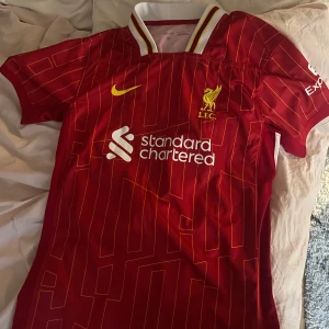 Liverpool 24/25 Alexander-Arnold tröja  - En Liverpool matchtröja med Alexander-Arnold och nummer 66 på ryggen. Perfekt för Liverpool fans eller för fans som vill minnas Trent för den spelaren han var för Liverpool. Säljs pga att den är för liten för mig. Storlek M