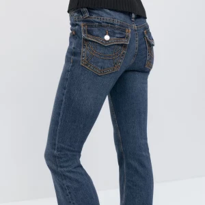 Blå bootcutjeans (SÖKER) - SÖKER DESSA snygga blå jeans med markerade kontrastsömmar och stora bakfickor med lock och knapp. Kontakta om ni säljer för ett billigt pris 🙈