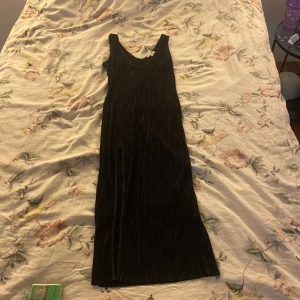 Svart långklänning från NLY One XS - Snygg svart långklänning från NLY One i storlek XS. Klänningen är ärmlös med v-ringning och har ett ribbat, plisserat tyg som ger en cool struktur. Perfekt för dig som gillar stilrena och trendiga plagg med lite edge. Några få skador på klänningen som oftast inte märks så som- pytte små hål osv. Dm för bild på skadorna!💗 ej blivit använd någon gång.