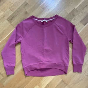 Rosa sweatshirt från House of Lola - Säljer en rosa sweatshirt från House of Lola i storlek S. Tröjan har rund halsringning, långa ärmar och en liten älva broderad på ena axeln. Mjuk bomullskvalitet och ribbade muddar vid ärmslut och nederkant. Perfekt för en chill och snygg look.
