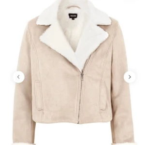 Beige teddyjacka med vit fuskpäls - Snygg beige teddyjacka från Bubbleroom med vit fuskpäls på krage och insida. Jackan har dragkedja framtill, croppad passform och långa ärmar. Perfekt för dig som vill ha en trendig och mysig look under höst och vinter.