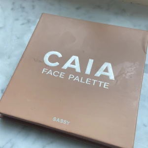 CAIA Face Palette Sassy - Snygg ansiktspalett från CAIA i färgen Sassy. Paletten innehåller flera olika puderprodukter för ansiktet, perfekt för att skapa en fräsch och glowig look. Kompakt och stilren design i beige med spegel. Vegansk och tillverkad i Italien. Pris kan diskuteras!!