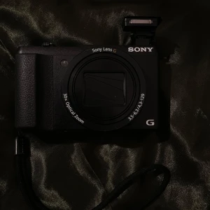 Sony - Sony digitalkamera med 30x optisk zoom, tillhörande väska från Lowepro och flera extrabatterier. Perfekt för dig som vill ta snygga bilder och videos på äventyr, resor eller vardag. Kompakt format och enkel att ta med överallt. Allt du behöver för att komma igång direkt!