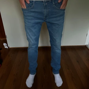 Replay Anbass slim fit jeans blå - Snygga blå Replay Anbass jeans i slim fit med klassisk femficksdesign. Jeansen är tillverkade i stretchigt Hyperflex-material som ger extra komfort och rörelsefrihet. Perfekta för dig som gillar en smalare passform och stilren look.