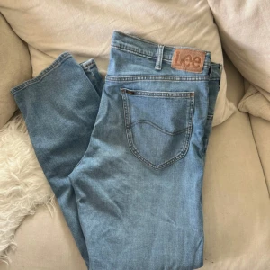Lee Daren Zip Fly ljusblå jeans - Säljer ett par klassiska Lee Daren Zip Fly jeans i ljusblå denim. Jeansen har raka ben, fem fickor och dragkedjegylf. Perfekta för dig som gillar en tidlös och avslappnad look. Materialet är bomull med en skön känsla. Fint skick. Knappt använda. Nypris övwr 1000kr 