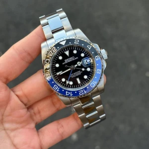 Seiko GMT-Master II blå/svart klocka - Stilren Seiko GMT-Master II med svart urtavla, blå och svart vridring samt tydliga vita index. Klockan har datumfönster med förstoringsglas och robust länkarmband i silverfärgat stål. Perfekt för dig som gillar klassisk design med en modern touch.