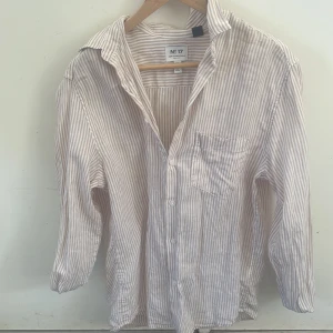 Beige-Randig långärmad skjorta  - Snygg randig skjorta i beige. Skjortan har klassisk krage, bröstficka och knäppning framtill. Tillverkad i lätt och luftig bomull, perfekt för varmare dagar. Långärmad och med avslappnad passform.