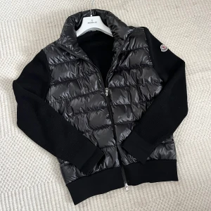MONCLER CARDIGAN TRICOT - Skitsnygg svart cardigan från Moncler! Köpt på NK:s hemsida. Storlek M, normal i storleken. Mycket bra skick, inget slitage. Nypris 10 800kr. Säljer pga använder inte längre. 