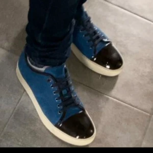 Blå mockasneakers från Lanvin FRI FRAKT! - Snygga sneakers från LANVIN i blå mocka med svarta lackdetaljer på tån och svarta snören.  Glansen på tån är helt felfri och skorna är i väldigt bra skick! Lite slitning på mockan men inget märkvärdigt!Perfekta skor inför vintern! Först Till Kvarn! Det är bara att skriva om ni har frågor eller annat! 