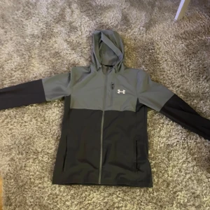Underarmour jacka/tröja  - Säljer denna under armour jack/ tröja då den inte kommer till användning köpt ny på jd sports för ca 1000kr minns inte riktigt, man kan använda den som både jacka och tröja jag brukar ha den både i skolan och när man är ute! Skriv för mer info