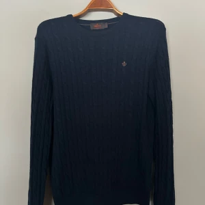 Mörkblå kabelstickad tröja Morris - Tjenare! Säljer nu denna mörkblå kabelstickade tröjan från Morris i 100% merinoull. Tröjan sitter riktigt gött och passar perfekt med en skjorta under. Perfekt nu inför hösten och funkar bra under en jacka. Passar dig som vill ha något både stilrent och bekvämt. Hör av er vid frågor!