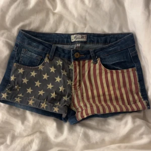 Jeansshorts Amerika  - Snygga jeanshorts med Amerika flaggan på. Inga defekter samt knappt använda. 