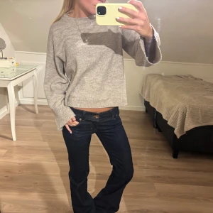 Beige stickad tröja med vida ärmar - Supermysig beige stickad tröja med lite croppad passform och vida, långa ärmar. Perfekt för lager-på-lager och chill dagar. Enkel och stilren design som funkar till det mesta. Snygg att matcha med jeans eller kjol.