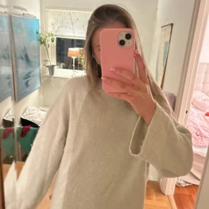 Ljusbeige stickad tröja från Gina Tricot - Supermjuk och oversized stickad tröja i ljusbeige från Gina Tricot. Tröjan har rund halsringning, långa ärmar och ribbade muddar vid ärmslut och nederkant. Perfekt för lager-på-lager och chill dagar.