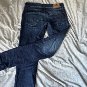 Mörkblå jeans från Replay Wallys - Snygga mörkblå jeans från Replay, modell Wallys. Klassisk femficksdesign med kontrastsömmar och Replay-logga på fickan. Jeansen har rak passform och är tillverkade i mjukt denimtyg som sitter skönt hela dagen. Jeansen är knappt använda och har inga täcken på användning. Hör gärna av dig vid minsta fundering 