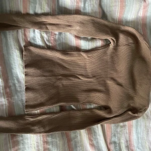 Beige ribbad v-ringad tröja Amisu - Säljer en beige ribbad långärmad tröja från Amisu i storlek S. Tröjan har en snygg v-ringning och är figurnära med stretchigt stickat material. Perfekt att styla med jeans eller kjol för en chill look.